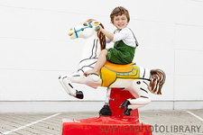F0045118-Boy_riding_mechanical_horse_outdoors-SPL.jpg